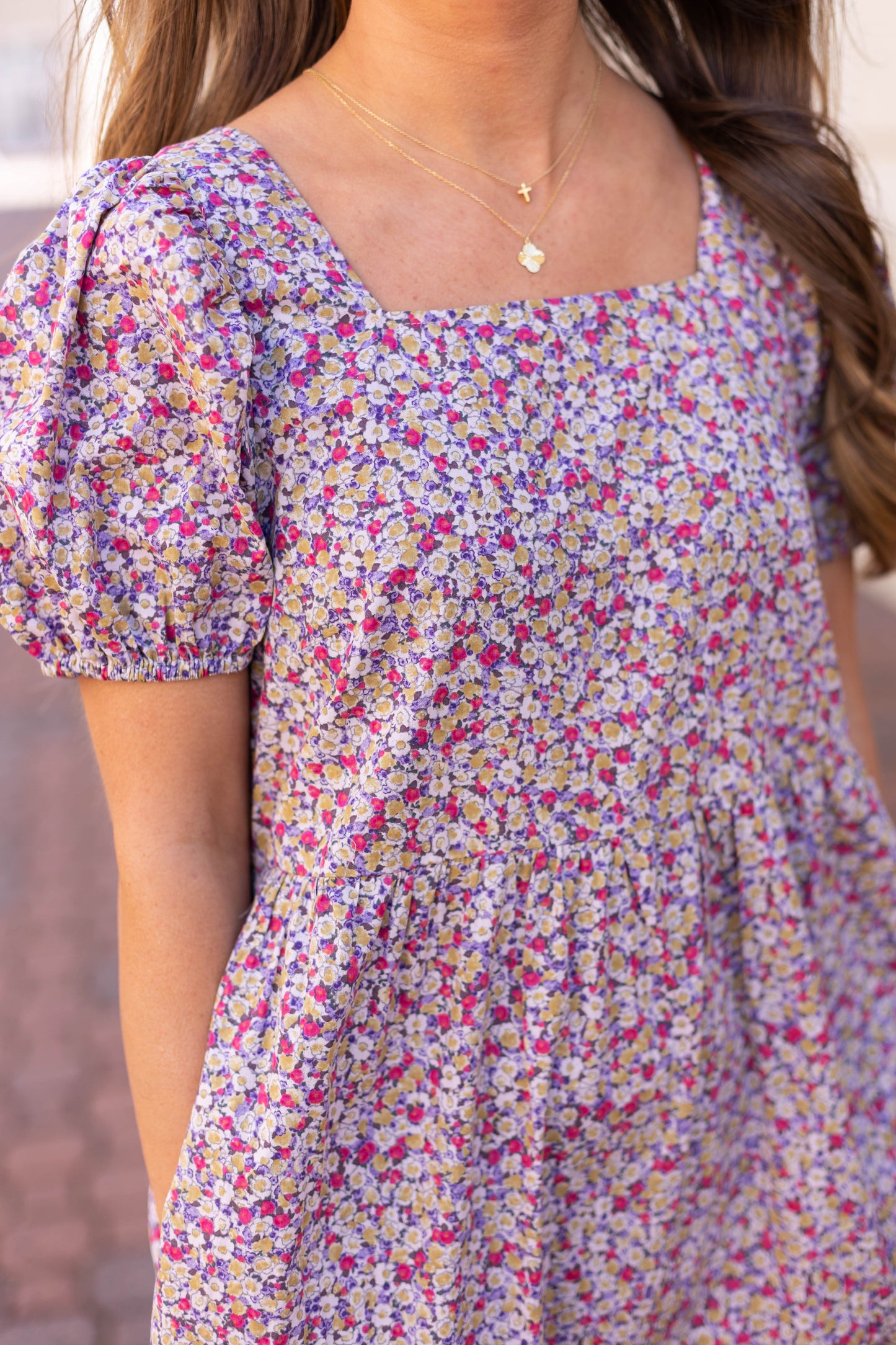 Dogwood Cloth's Jasmine Floral Maxi Dress exudes effortless elegance with its puffed sleeves, paired with gold necklaces, and crafted from breathable cotton for a comfortable and stylish look.