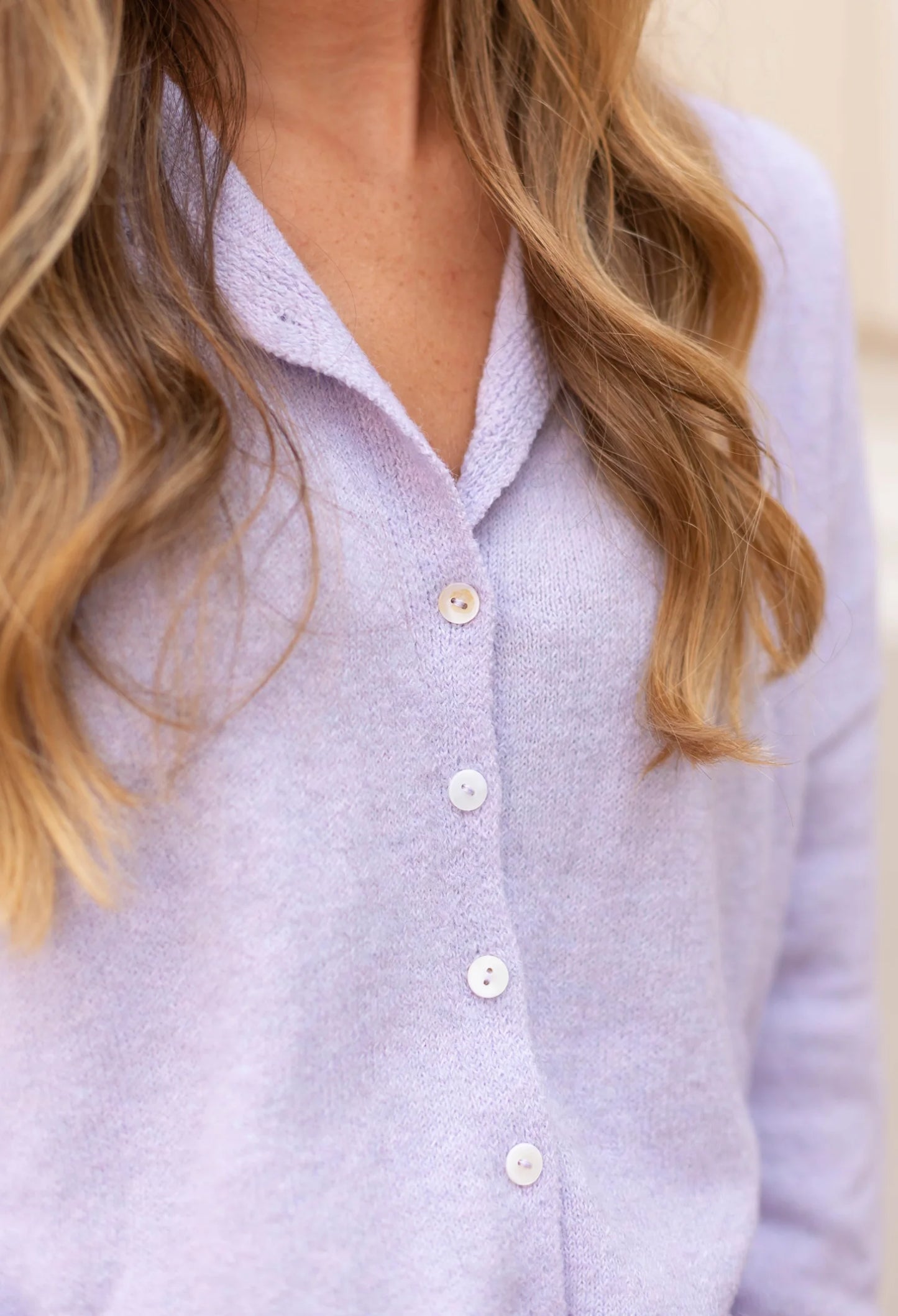 A woman is wearing a Dogwood Cloth Iris Lavender Sweater, with her long wavy hair visible in the image.